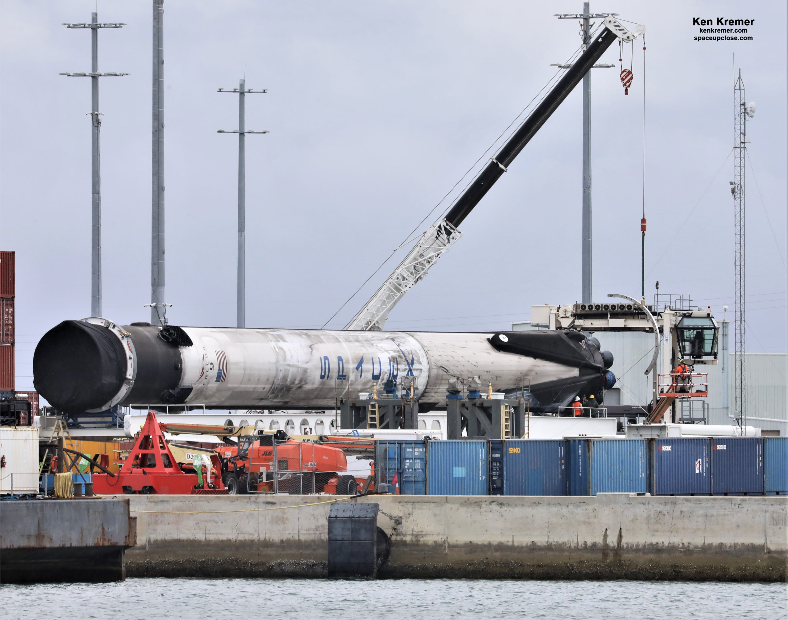 Falcon 9 Booster from 1st Human Launch Lowered and Transported to Cape, Fate TBD: Photos